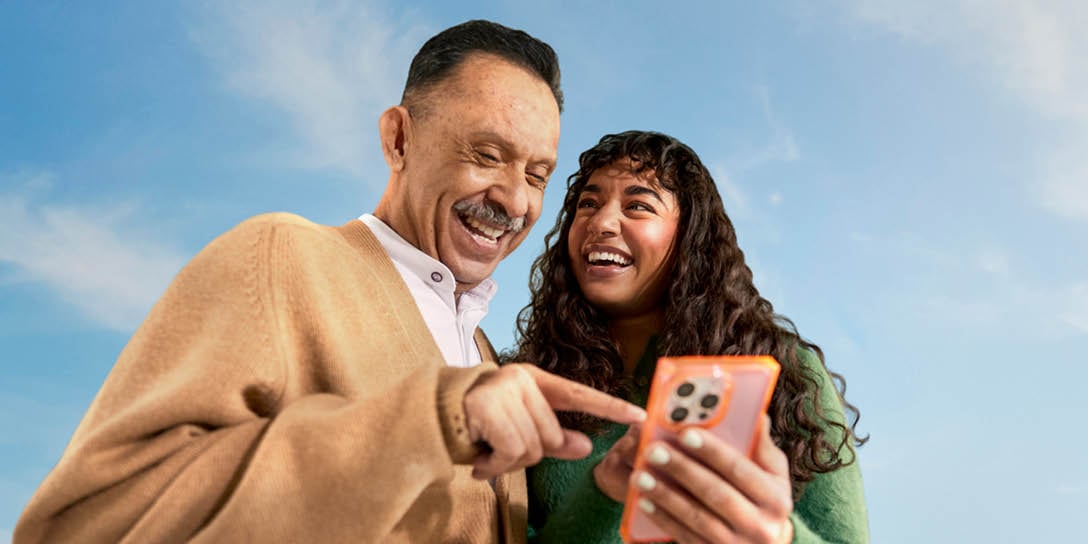 Two people complete a customer satisfaction survey on a cell phone.