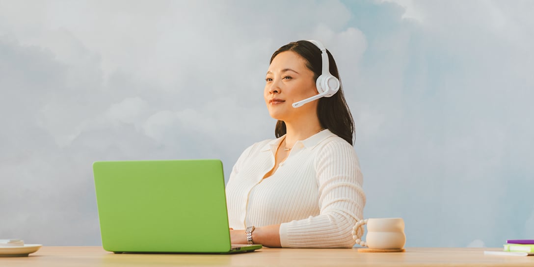A support agent sits behind a laptop, using customer service skills to help callers.