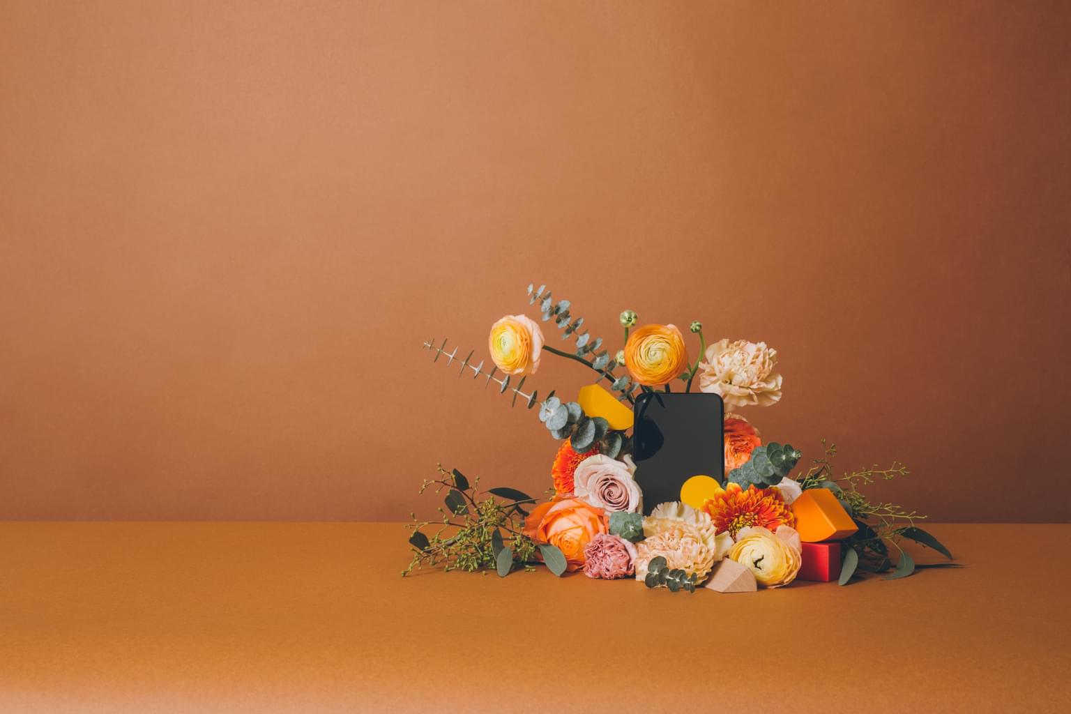 Leverera innehållsrika konversationer Bildbeskrivning: En mobiltelefon omgiven av ett fräckt blomsterarrangemang